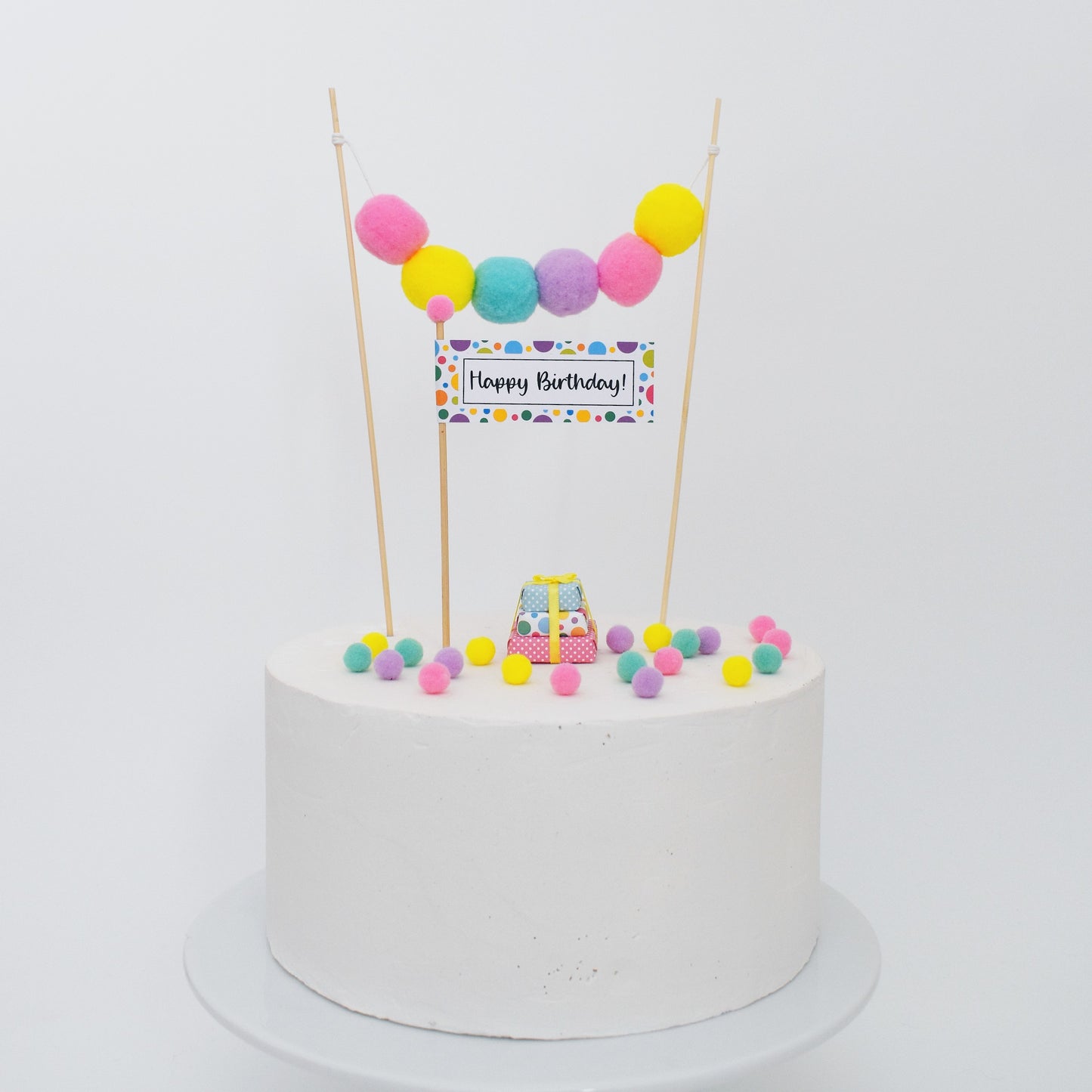 bright rainbow pom pom cake garland