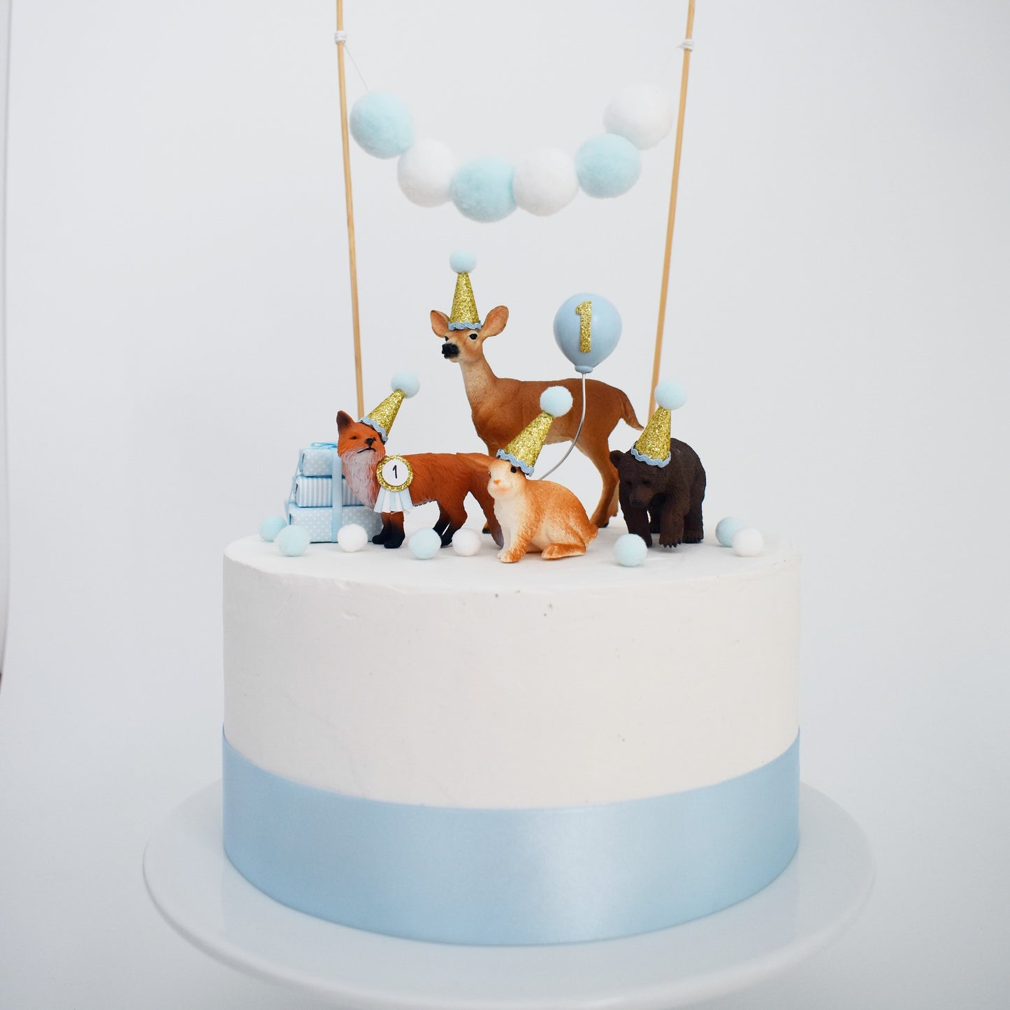 blue woodland party animal first birthday cake