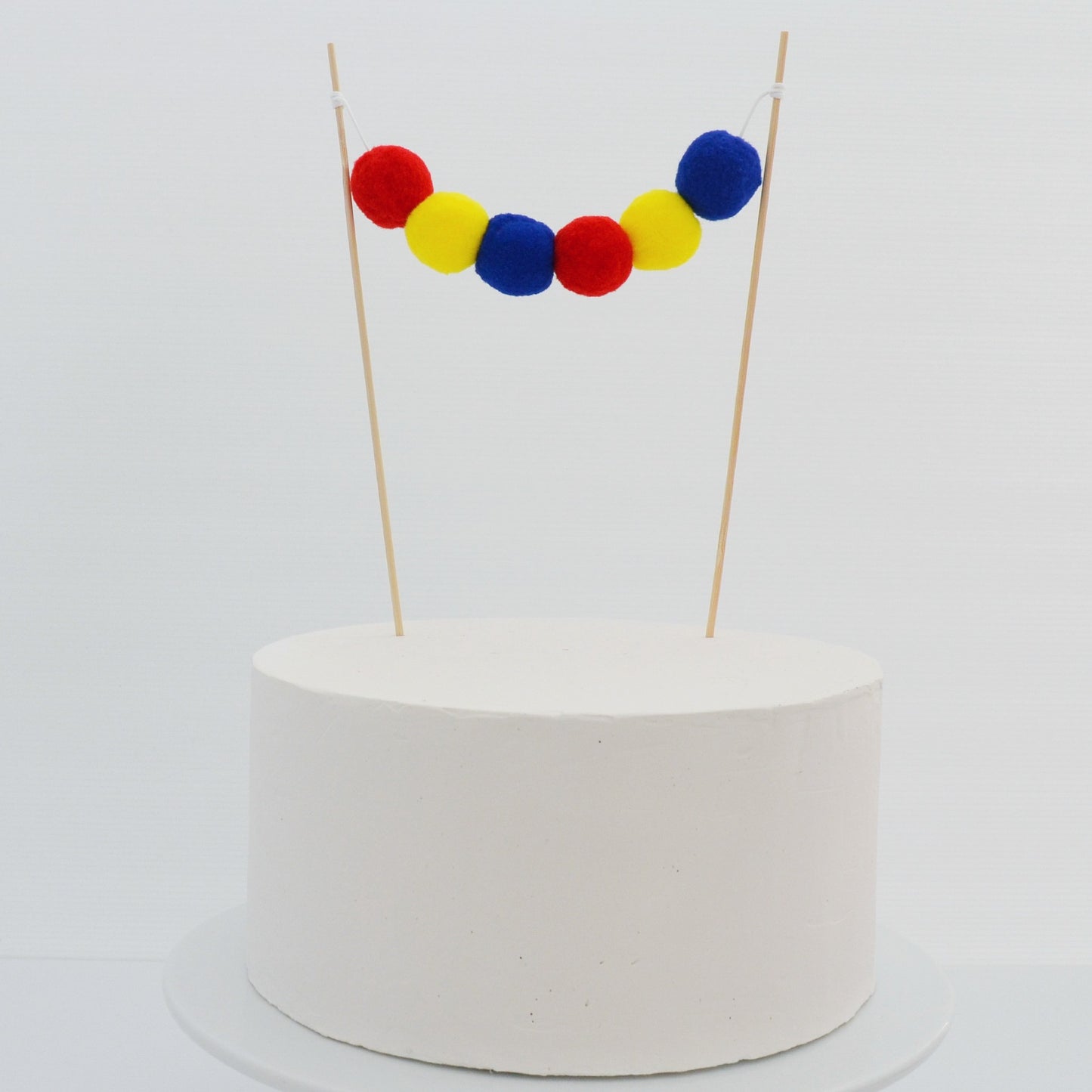 Pom Pom Garland Cake Topper in Red, Yellow & Blue