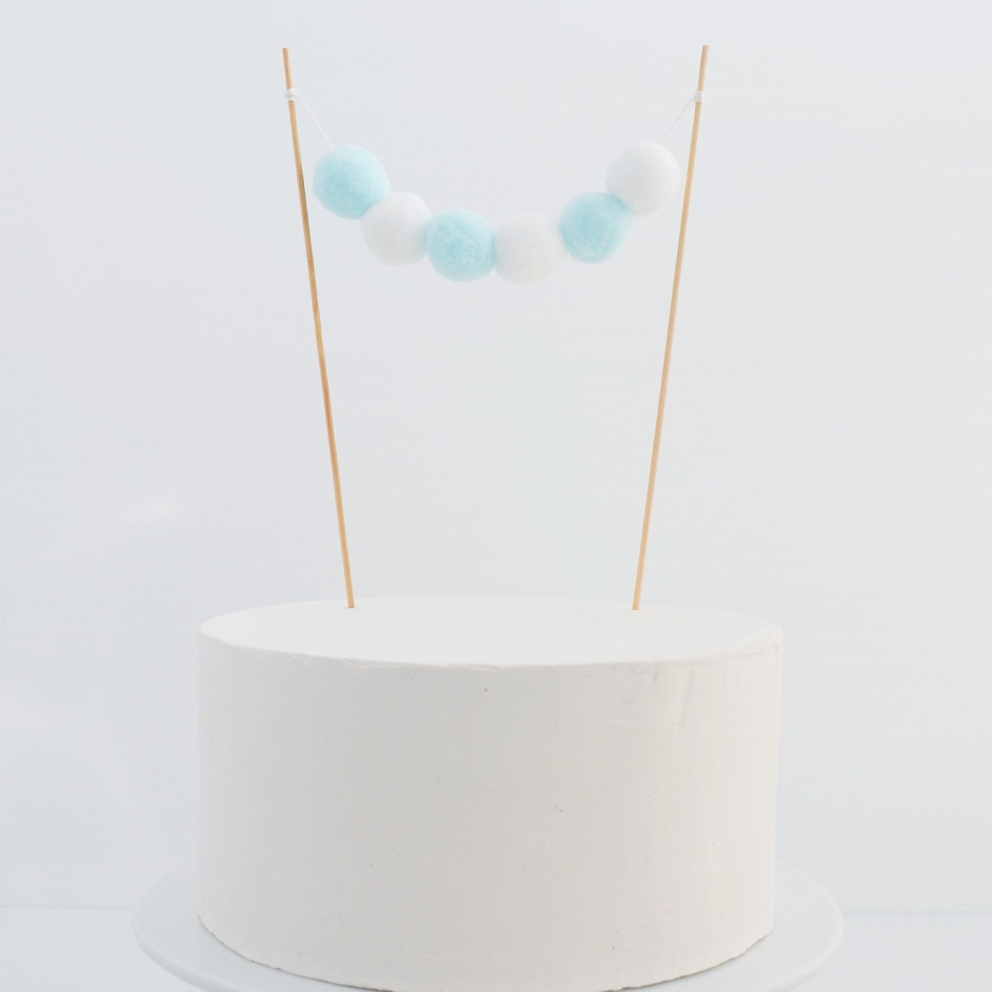 blue and whote pom pom garland cake topper 