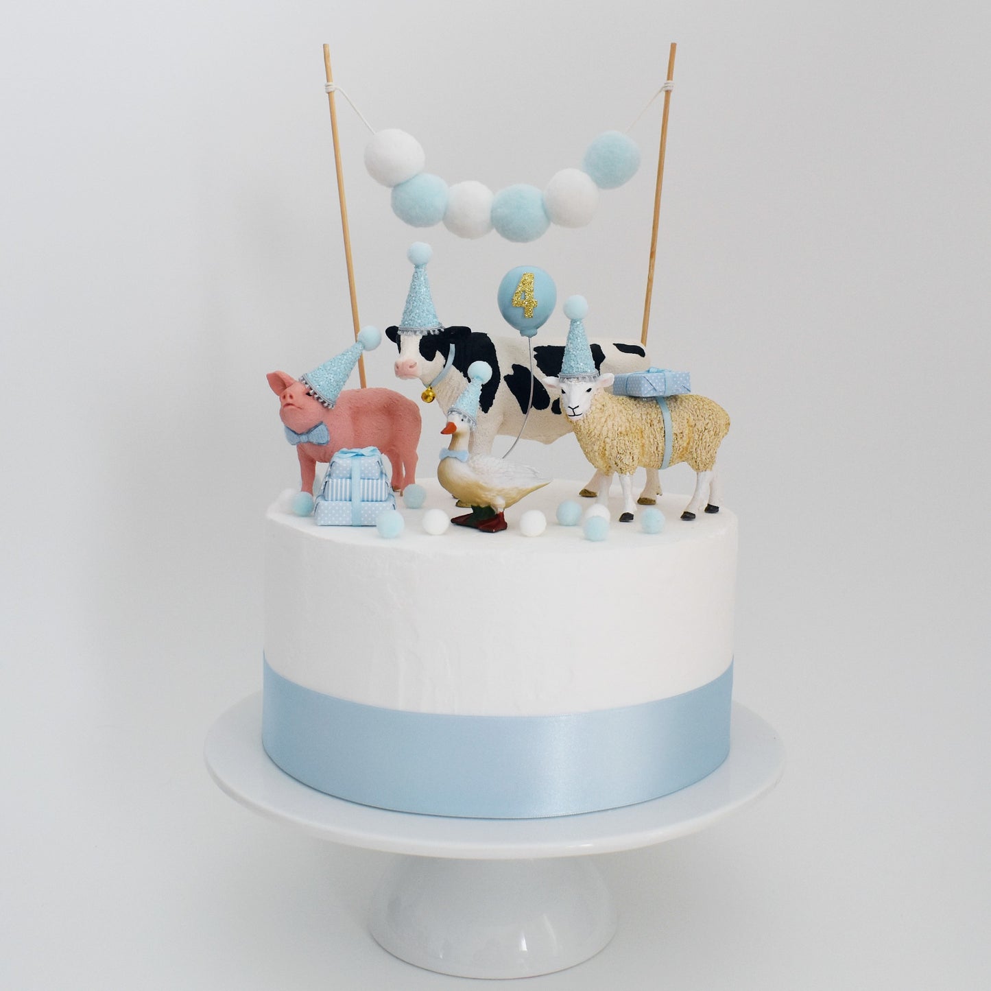 boys blue farm animals with party hats and balloon farm themed birthday cake