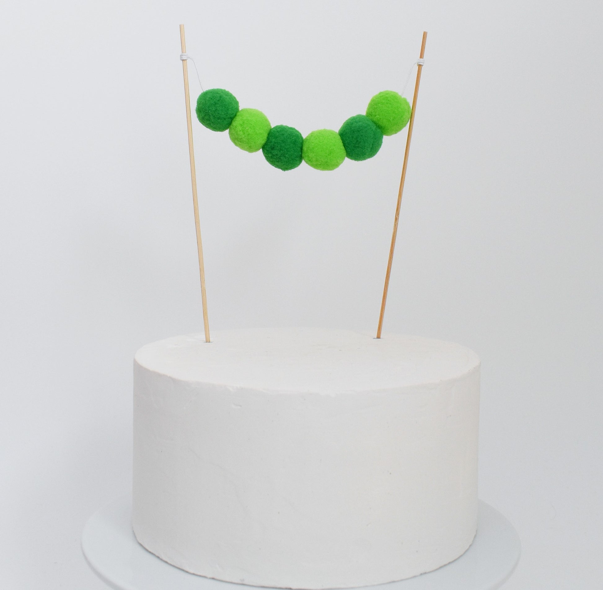 green pom pom cake garland