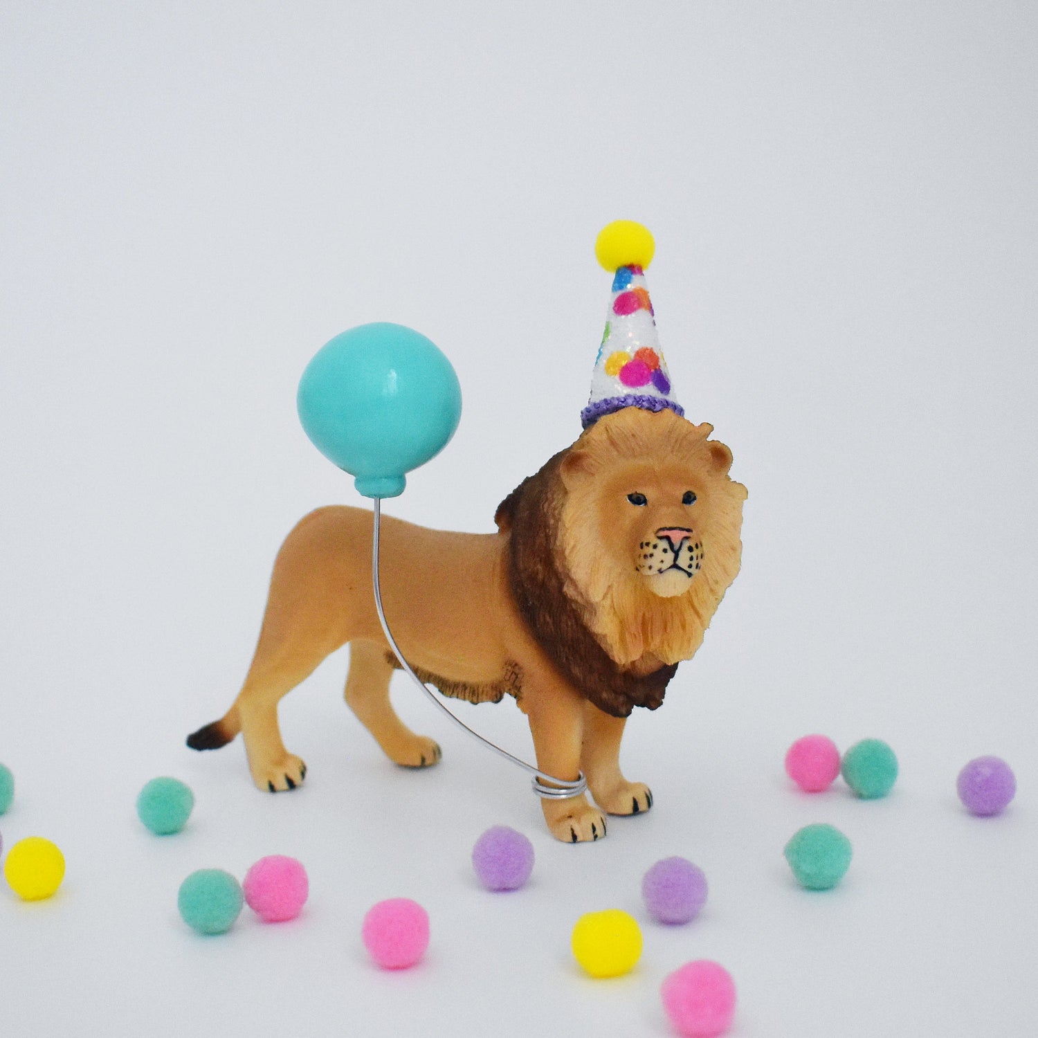 lion with rainbow party hat and balloon